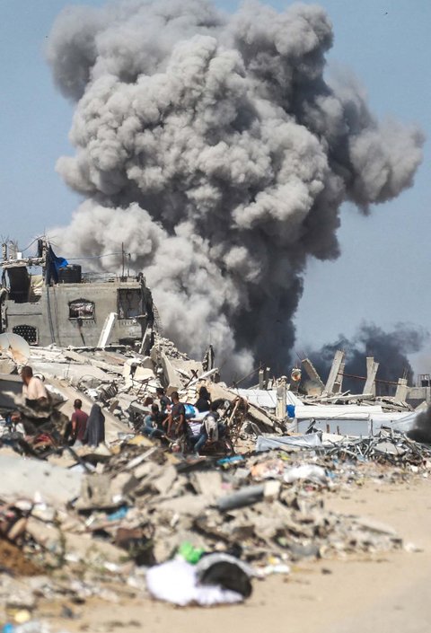 Warga Palestina mengangkut barang-barang mereka saat mereka melarikan diri dari Jalur Gaza utara ke selatan, di sepanjang jalan pesisir al-Rashid, Minggu (25/05/2025).