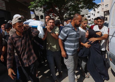 Keluarga  berduka di dekat jenazah warga Palestina yang tewas sehari sebelumnya akibat tembakan Israel saat antri mendapatkan bantuan pangan, di kamar mayat rumah sakit Al-Shifa di Kota Gaza, Rabu (18/06/2025).
