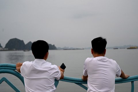 Keluarga korban kapal wisata yang terbalik menunggu informasi tentang orang yang mereka cintai di dermaga Teluk Ha Long, Provinsi Quang Ninh, Vietnam, Minggu (20/07/2025).