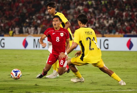 Pesepak bola Timnas U-23 Indonesia Muhammad Rayhan tersungkur   saat berebut bola dengan pesepak bola Timnas U-23 Malaysia dalam pertandingan penyisihan Grup A Piala AFF U-23 2025 di Stadion Utama Gelora Bung Karno (SUGBK), Senayan, Jakarta, Senin (21/7/2025).