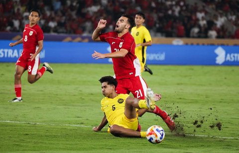 Pesepak bola Timnas U-23 Indonesia Jens Raven terjatuh saat berebut bola dengan pesepak bola Timnas U-23 Malaysia Muhammad Shafizan dalam pertandingan penyisihan Grup A Piala AFF U-23 2025 di Stadion Utama Gelora Bung Karno (SUGBK), Senayan, Jakarta, Senin (21/7/2025).