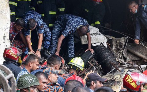 Petugas pemadam kebakaran dan keamanan Bangladesh melakukan proses evakuasi  setelah sebuah jet latih Angkatan Udara jatuh di sebuah sekolah di Dhaka, Bangladesh, Senin (21/07/2025).