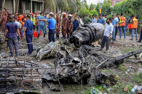Petugas pemadam kebakaran dan keamanan Bangladesh melakukan proses evakuasi  setelah sebuah jet latih Angkatan Udara jatuh di sebuah sekolah di Dhaka, Bangladesh, Senin (21/07/2025).