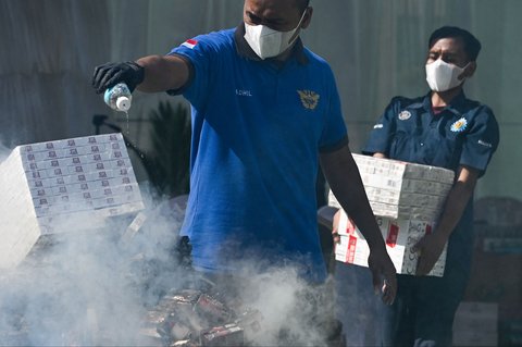 Petugas Bea Cukai membakar rokok sitaan dari perdagangan ilegal di Banda Aceh, Selasa (22/07/2025).