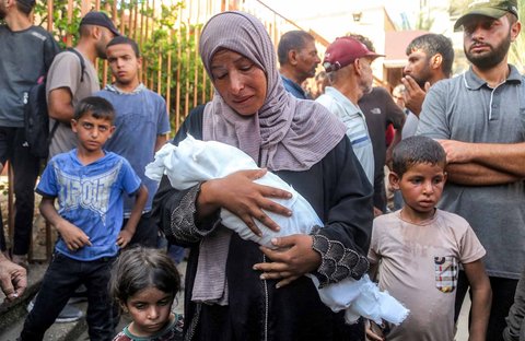 Ibu Yahya Fadi al-Najjar, seorang bayi yang meninggal dunia akibat kekurangan gizi, berduka sambil memegang jenazah anaknya di Kompleks Medis Nasser di Khan Yunis, Jalur Gaza selatan, Minggu, (20/07/2025).