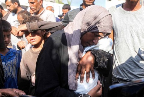 Ibu Yahya Fadi al-Najjar, seorang bayi yang meninggal dunia akibat kekurangan gizi, berduka sambil memegang jenazah anaknya di Kompleks Medis Nasser di Khan Yunis, Jalur Gaza selatan, Minggu, (20/07/2025).