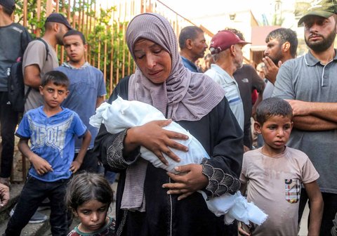 Ibu Yahya Fadi al-Najjar, seorang bayi yang meninggal dunia akibat kekurangan gizi, berduka sambil memegang jenazah anaknya di Kompleks Medis Nasser di Khan Yunis, Jalur Gaza selatan, Minggu, (20/07/2025).
