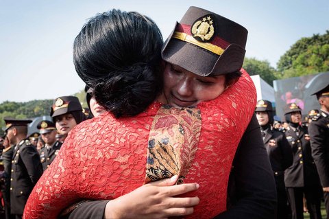 Seorang perwira polisi baru Indonesia dipeluk ibunya yang memberikan ucapan selamat setelah upacara pelantikan sekitar 2.000 lulusan Akademi Militer dan Kepolisian di Istana Kepresidenan, Jakarta, Rabu (23/07/2025).