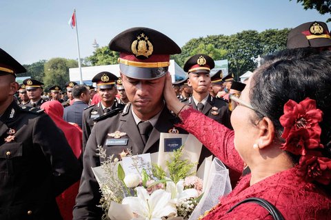 Seorang perwira polisi baru Indonesia mendapatkan  ucapan selamat dari ibunya setelah upacara pelantikan sekitar 2.000 lulusan Akademi Militer dan Kepolisian di Istana Kepresidenan, Jakarta, Rabu (23/07/2025).