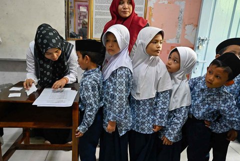Petugas Pusat Kesehatan Masyarakat (Puskesmas) mendata nama murid saat Cek Kesehatan Gratis (CKG) di sekolah Madrasah Ibtidaiyah Negeri 6 Banda Aceh, Aceh, Rabu (23/07/2025).