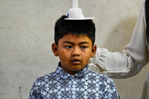 Petugas Pusat Kesehatan Masyarakat (Puskesmas) memeriksa kesehatan murid saat kegiatan Cek Kesehatan Gratis (CKG) di sekolah Madrasah Ibtidaiyah Negeri 6 Banda Aceh, Aceh, Rabu (23/07/2025).