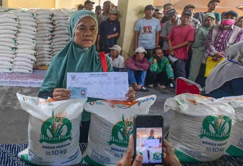 Keluarga Penerima Bantuan Pangan (PBP)  antri untuk menerima Bantuan Pangan Non Tunai (BPNT)  beras 20 kg di Kantor Kelurahan Rangkapan Jaya Baru, Depok, Jawa Barat, Kamis, (24/07/2025)