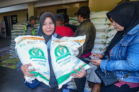 Keluarga Penerima Bantuan Pangan (PBP)  antri untuk menerima Bantuan Pangan Non Tunai (BPNT)  beras 20 kg di Kantor Kelurahan Rangkapan Jaya Baru, Depok, Jawa Barat, Kamis, (24/07/2025)
