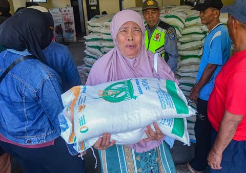 Keluarga Penerima Bantuan Pangan (PBP)  menerima Bantuan Pangan Non Tunai (BPNT)  beras 20 kg di Kantor Kelurahan Rangkapan Jaya Baru, Depok, Jawa Barat, Kamis, (24/07/2025)