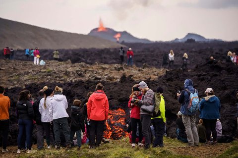 Wisatawan  mengamati kawah aktif setelah letusan gunung berapi sekitar 6 km di Semenanjung Reykjanes, Islandia, Rabu, (23/07/2025).