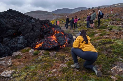 Wisatawan mengambil foto lava cair, setelah letusan gunung berapi di Semenanjung Reykjanes, Islandia, Rabu, (23/07/2025).