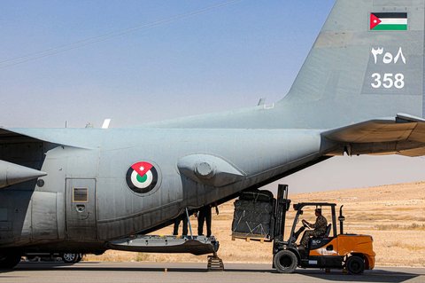 Paket bantuan kemanusiaan sedang dimuat ke pesawat angkut militer C-130 Hercules Angkatan Udara Kerajaan Yordania di sebuah lapangan terbang sebagai bagian dari misi pengiriman bantuan kemanusiaan ke Jalur Gaza di Yordania, Minggu (27/07/2025).