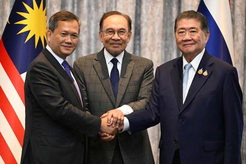 Perdana Menteri Kamboja Hun Manet (kiri) dan Penjabat Perdana Menteri Thailand Phumtham Wechayachai (kanan) berjabat tangan bersama Perdana Menteri Malaysia Anwar Ibrahim setelah perundingan perundingan gencatan senjata antara Thailand dan Kamboja di Putrajaya, Malaysia, Senin (28/07/2025).