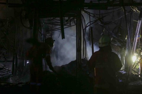Petugas pemadam kebakaran memadamkan sisa api yang membakar PasarTaman Puring, Jakarta Selatan, Senin (28/7/2025).