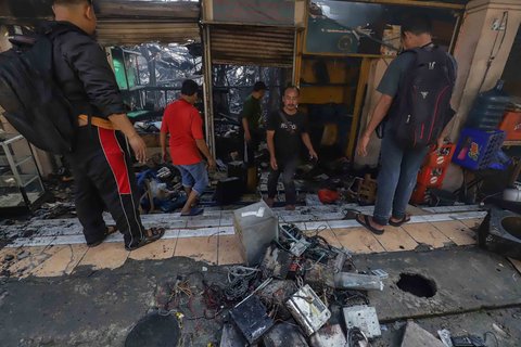 Sejumlah pedagang mengais puing dan sisa barang dagangan yang hangus terbakar di Pasar Taman Puring, Jakarta Selatan, Selasa (29/7/2025).