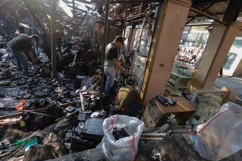 Sejumlah pedagang mengais puing dan sisa barang dagangan yang hangus terbakar di Pasar Taman Puring, Jakarta Selatan, Selasa (29/7/2025).