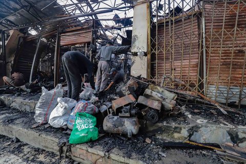 Sejumlah pedagang mengais puing dan sisa barang dagangan yang hangus terbakar di Pasar Taman Puring, Jakarta Selatan, Selasa (29/7/2025).