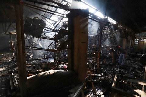 Sejumlah pedagang mengais puing dan sisa barang dagangan yang hangus terbakar di Pasar Taman Puring, Jakarta Selatan, Selasa (29/7/2025).