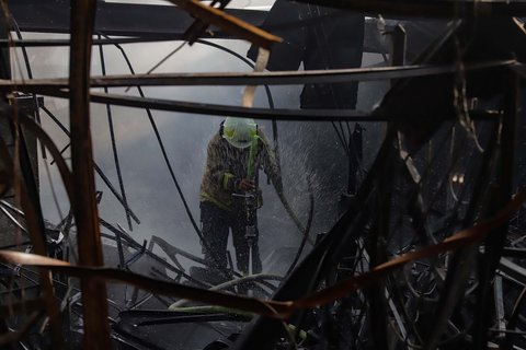 Petugas pemadam kebakaran melakukan pendinginan  di Pasar Taman Puring, Jakarta Selatan, Selasa (29/7/2025).