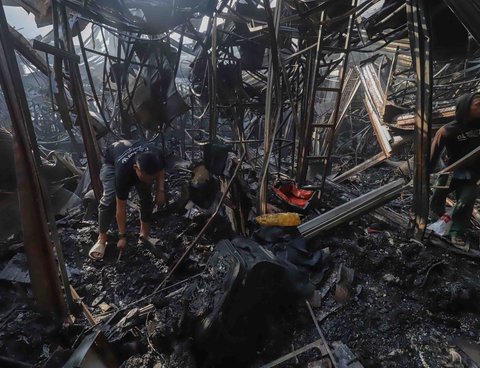 Sejumlah pedagang mengais puing dan sisa barang dagangan yang hangus terbakar di Pasar Taman Puring, Jakarta Selatan, Selasa (29/7/2025).