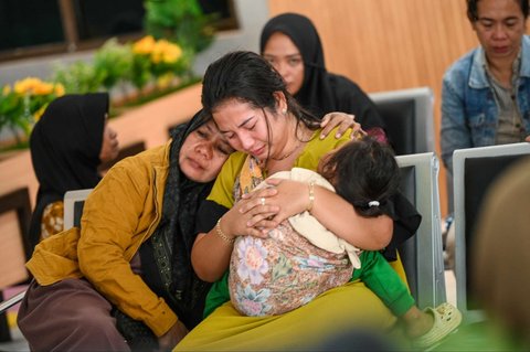 Sejumlah keluarga dan kerabat korban menangis saat menanti kabar penumpang kapal feri KMP Tunu Pratama Jaya yang tenggelam di perairan selat Bali di Pelabuhan Ketapang, Banyuwangi, Jawa Timur, pada Kamis (3/7/2025).