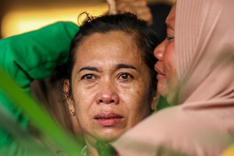 Sejumlah keluarga dan kerabat korban menangis saat menanti kabar penumpang kapal feri KMP Tunu Pratama Jaya yang tenggelam di perairan selat Bali di Pelabuhan Ketapang, Banyuwangi, Jawa Timur, pada Kamis (3/7/2025).