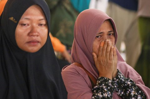 Sejumlah keluarga dan kerabat korban menangis saat menanti kabar penumpang kapal feri KMP Tunu Pratama Jaya yang tenggelam di perairan selat Bali di Pelabuhan Ketapang, Banyuwangi, Jawa Timur, pada Kamis (3/7/2025).