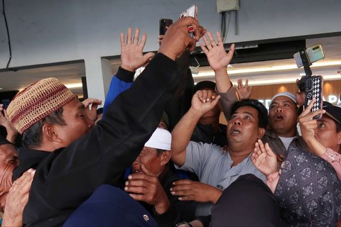 Sejumlah keluarga dan kerabat korban bereaksi ketika menerima panggilan video dengan survivor kapal feri KMP Tunu Pratama Jaya yang tenggelam di perairan selat Bali di Pelabuhan Ketapang, Banyuwangi, Jawa Timur, pada Kamis (3/7/2025).