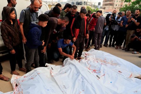 Para pelayat berdiri di dekat jenazah warga Palestina yang terbunuh akibat tembakan Israel di dekat lokasi distribusi bantuan di Rafah, pada 3 Juni 2025.