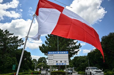 Bendera peringatan tsunami merah putih berkibar di pintu masuk Taman Tepi Laut Inage, Jepang, Rabu (30/07/2025).