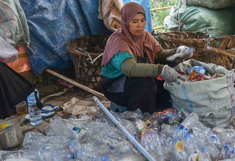 Pekerja mengolah sampah botol plastik menjadi cacahan plastik sebagai bahan biji plastik di Koperasi Pemulung Berdaya atau Recycle Business Unit (RBU) Tangerang Selatan, Tangerang, Banten, Rabu (30/07/2025).