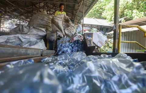 Pekerja mengolah sampah botol plastik menjadi cacahan plastik sebagai bahan biji plastik di Koperasi Pemulung Berdaya atau Recycle Business Unit (RBU) Tangerang Selatan, Tangerang, Banten, Rabu (30/07/2025).