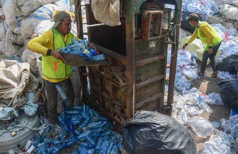 Pekerja mengolah sampah botol plastik menjadi cacahan plastik sebagai bahan biji plastik di Koperasi Pemulung Berdaya atau Recycle Business Unit (RBU) Tangerang Selatan, Tangerang, Banten, Rabu (30/07/2025).