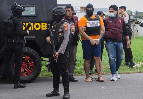 Petugas mengawal warga negara Australia yang diidentifikasi berinisial MC, untuk   mengikuti rekontruksi kepolisian di Badung, Bali, Rabu (30/07/2025).