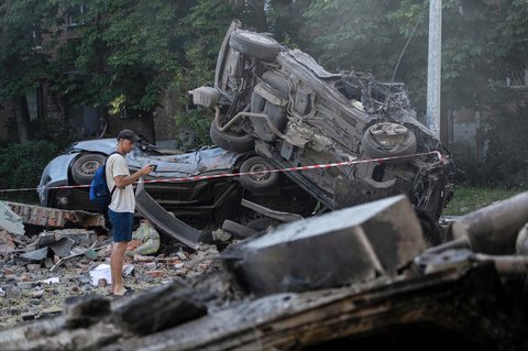 Seorang pria melihat reruntuhan mobil setelah serangan massal pesawat nirawak dan rudal Rusia di ibu kota Ukraina, Kyiv,  Jumat (04/07/2025) <br />AFP/ Oleksii Filippov