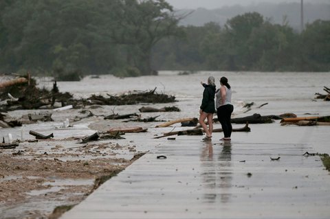 Dua karyawan yang tidak ingin disebutkan namanya, dari HTR RV Park, melihat ke area tempat puluhan trailer tersapu oleh banjir  bandang  di Sungai Guadalupe di Ingram, Texas, Jumat,  (04/07/2025).