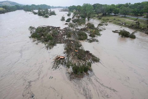 Sungai Guadalupe yang meluap meninggalkan pohon tumbang dan puing-puing di sepanjang alirannya,  Jumat,  (04/07/2025)  di Kerrville, Texas.