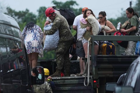 Petugas tanggap darurat membawa warga ke pusat reunifikasi setelah banjir bandang di daerah tersebut di Ingram, Texas, Jumat,  (04/07/2025).