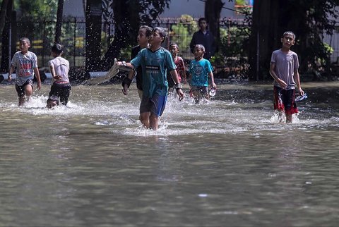 Aktivitas warga saat banjir merendam pemukiman di kawasan Kampung Makasar, Jakarta Timur, Senin (07/07/2025).