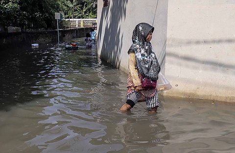 Aktivitas warga saat banjir merendam pemukiman di kawasan Kampung Makasar, Jakarta Timur, Senin (07/07/2025).