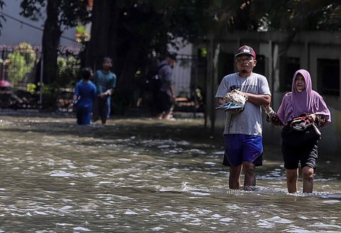 Aktivitas warga saat banjir merendam pemukiman di kawasan Kampung Makasar, Jakarta Timur, Senin (07/07/2025).