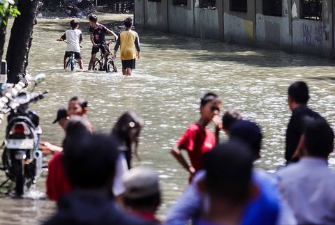 Aktivitas warga saat banjir merendam pemukiman di kawasan Kampung Makasar, Jakarta Timur, Senin (07/07/2025).