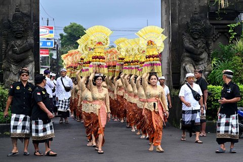Wanita Bali membawa sesaji di atas kepalanya saat prosesi menuju Pura Taman Ayun untuk upacara penobatan Anak Agung Gde Agung sebagai Ida Cokorda (raja) Mengwi ke-13 di Mangupura, Kabupaten Badung, Bali Senin (07/07/2025).