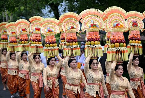 Wanita Bali membawa sesaji di atas kepalanya saat prosesi menuju Pura Taman Ayun untuk upacara penobatan Anak Agung Gde Agung sebagai Ida Cokorda (raja) Mengwi ke-13 di Mangupura, Kabupaten Badung, Bali Senin (07/07/2025).