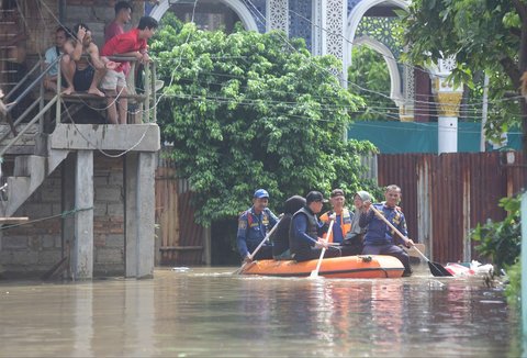 Petugas pemadam kebakaran mengevakuasi warga yang terjebak banjir di Kampung Cantiga, Petir, Cipondoh, Kota Tangerang, pada Selasa (8/7/2025). Kawasan Tangerang saat ini dikepung banjir akibat meluapnya Kali Angke. Sementara, ketinggian banjir yang merendam Kampung Cantiga mencapai 1,8 meter.